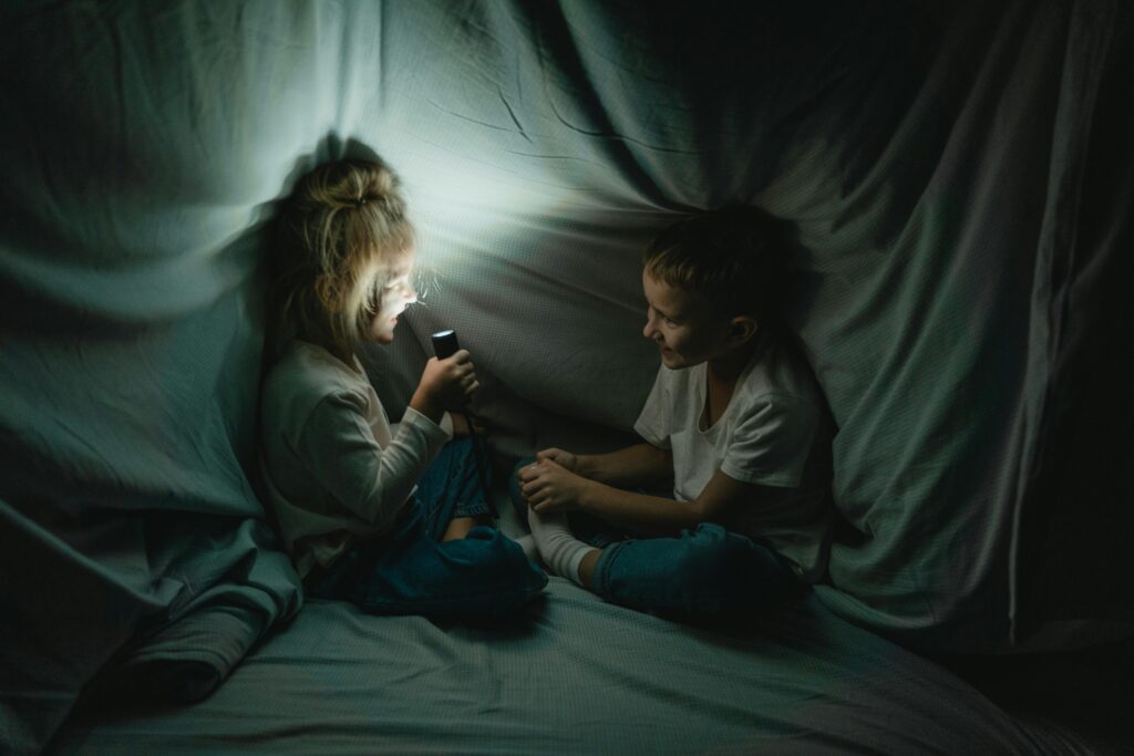 two kids in a blanket fort